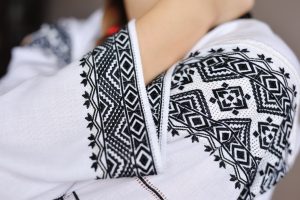 The girl in an embroidered shirt. Closeup pattern on the sleeve.